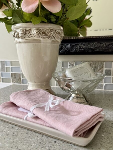 2 pink linen wash cloths, glass and silver dish with soap, vintage vase