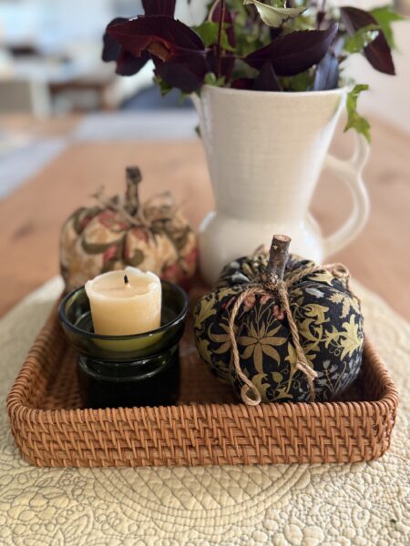 fabric pumpkins, candle in green glass candle holder and white ceramic vase